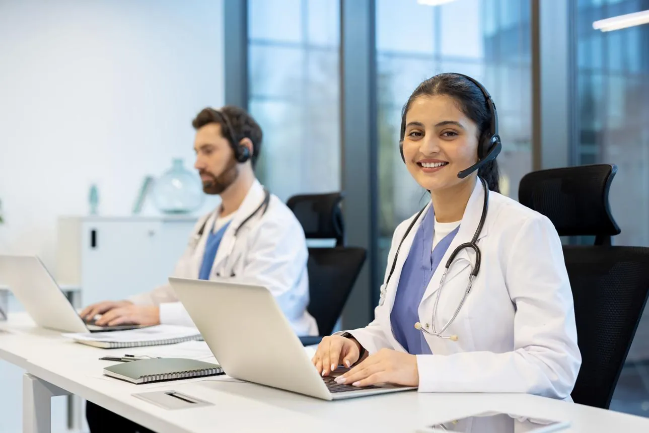 Hospital team member using a headset and laptop to handle patient calls, appointments and follow-ups with AI voice agent support
